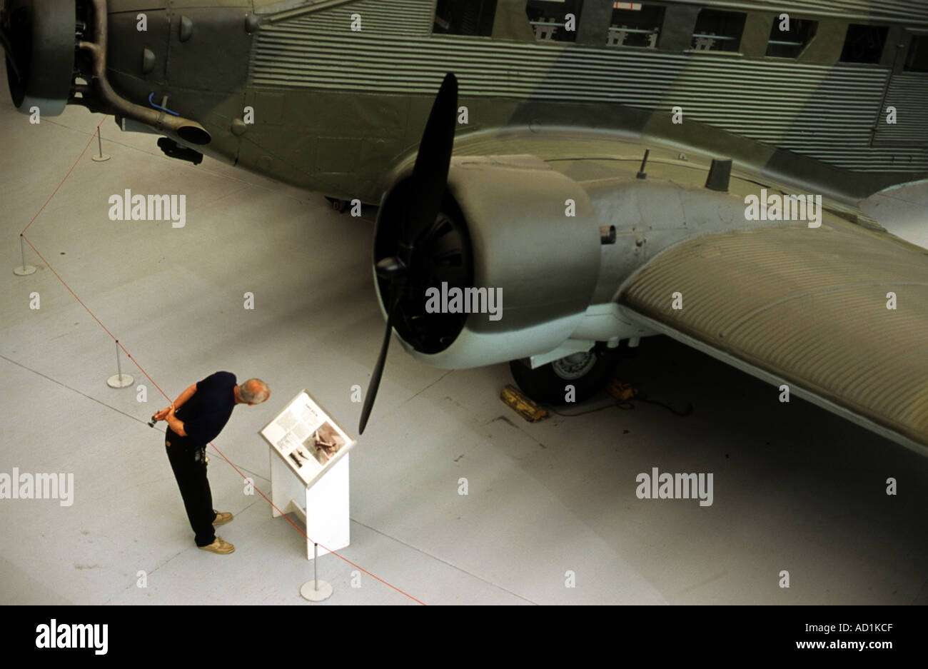 A visitor reading information about a Junkers Ju52 WW2 German aircraft at the Imperial War Museum, Duxford, UK. Stock Photo