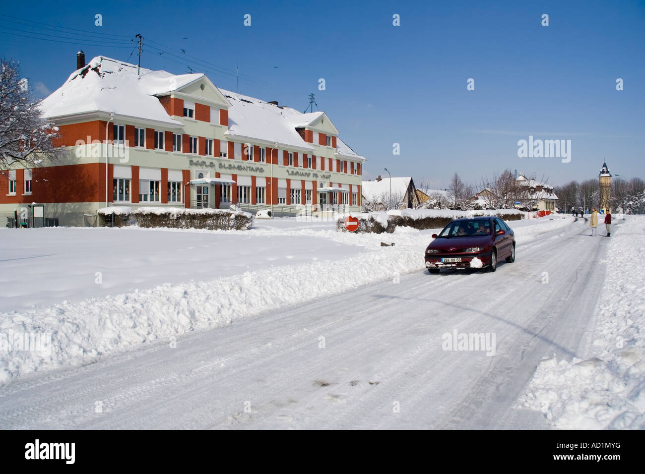 Carefully driving past school after snowfall, Alsace, France Stock Photo