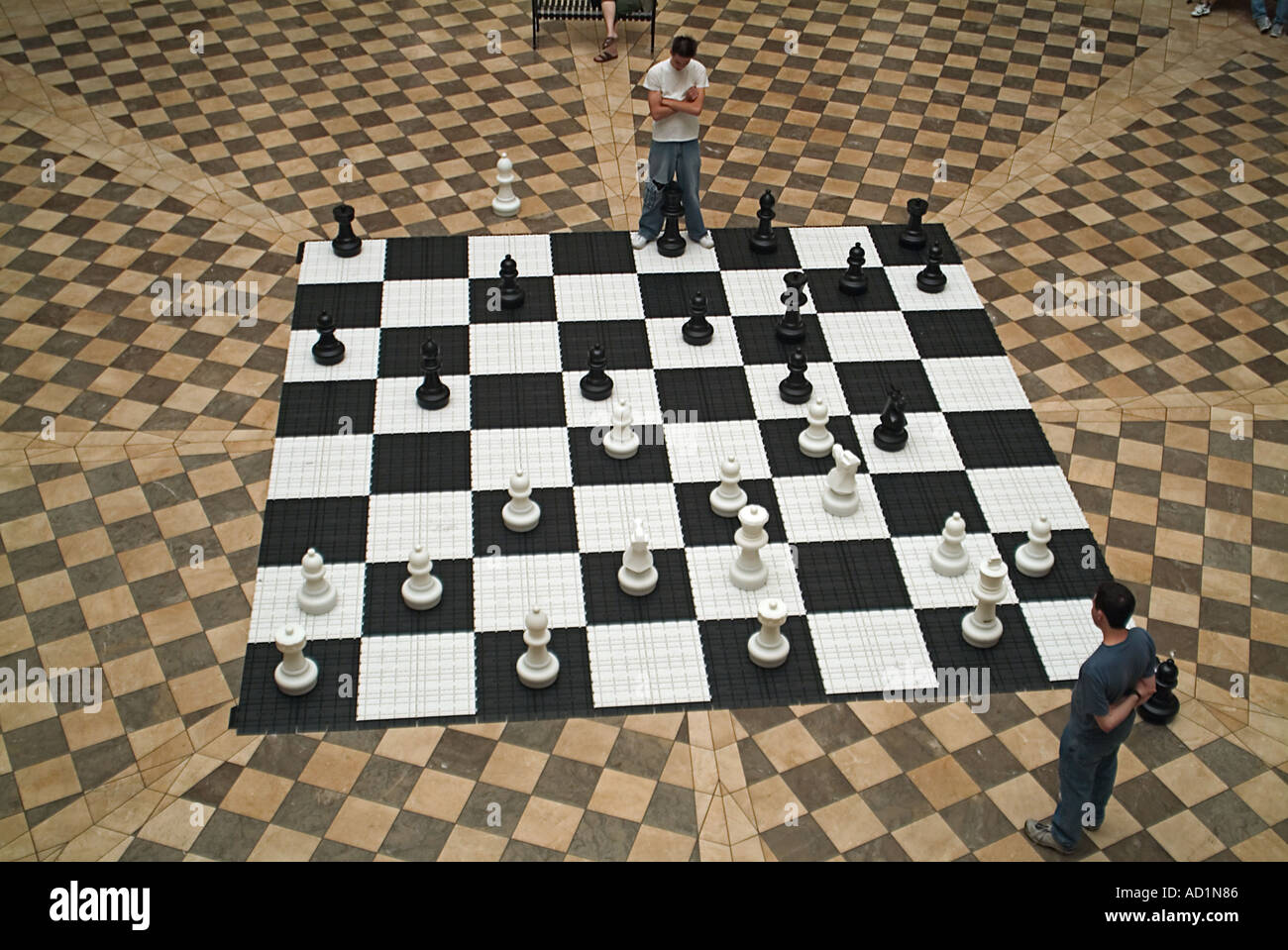 Giant chess board in a Burbank Town Center with 2 teenage Boys challenging each other in a game