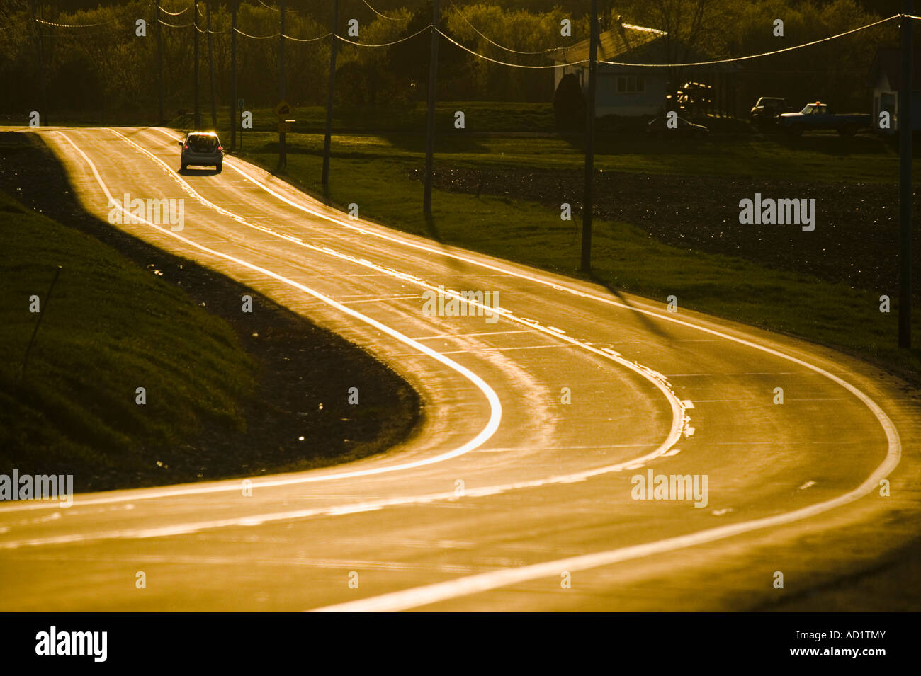 Golden road curves into western sunset upstate New York NY Stock Photo