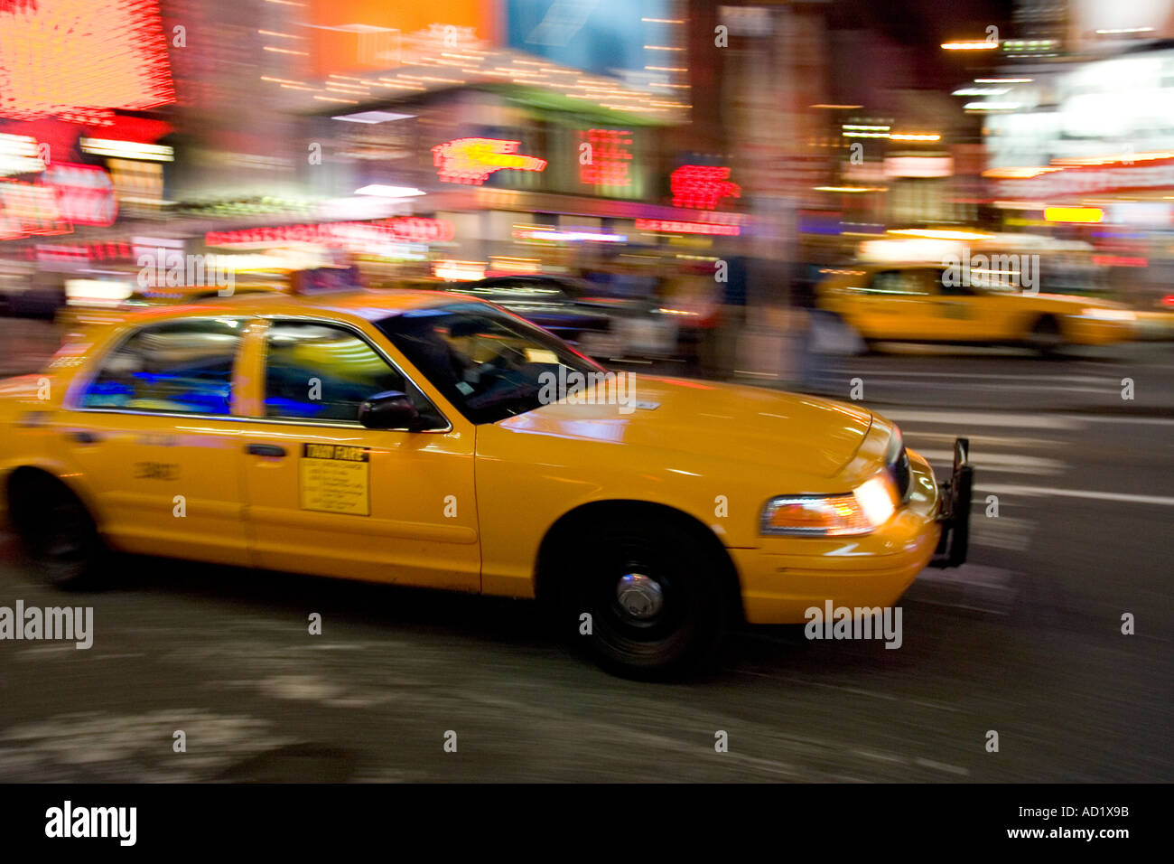 Yellow Cab racing through Times Square at night Stock Photo - Alamy