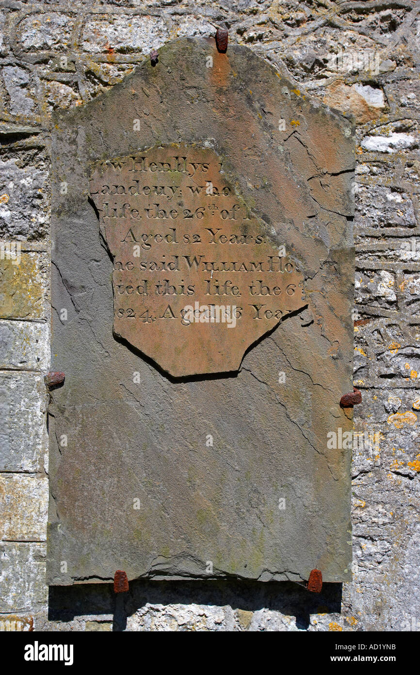 Ancient Headstone attached to The Parish Church of St Rhidian and St Illtyd in Llanrhidian, on the Gower Peninsular, Wales, UK Stock Photo