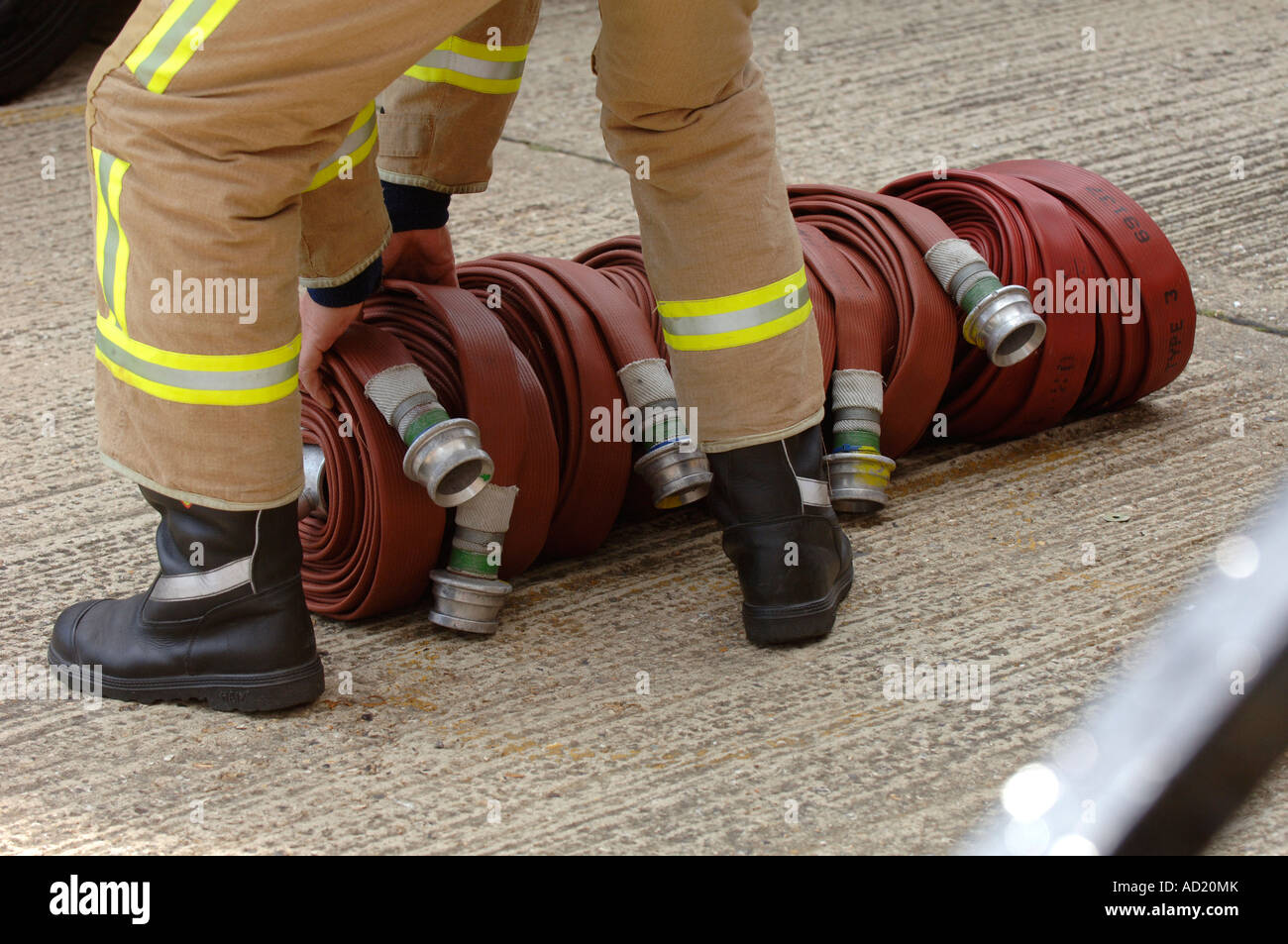 A fireman prepares fire hoses coiled ready for use. Picture by Jim Holden. Stock Photo