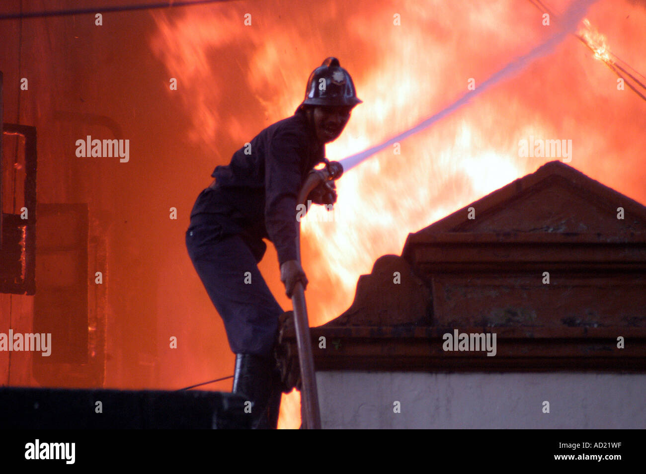 Fireman spraying water fighting fire Stock Photo