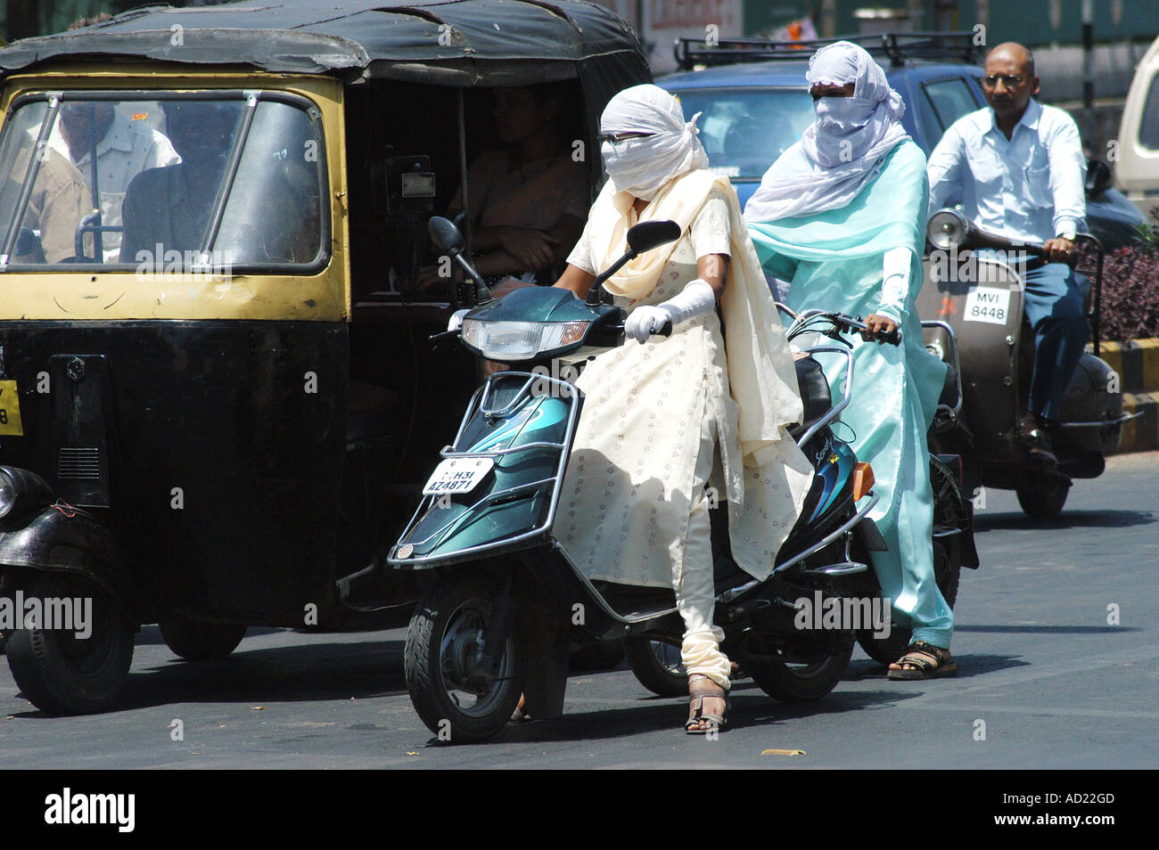 ASB73158 Two wheeler motor bike riders cover faces with scarfs to avoid summer heat and pollution at Nagpur Maharashtra India Stock Photo
