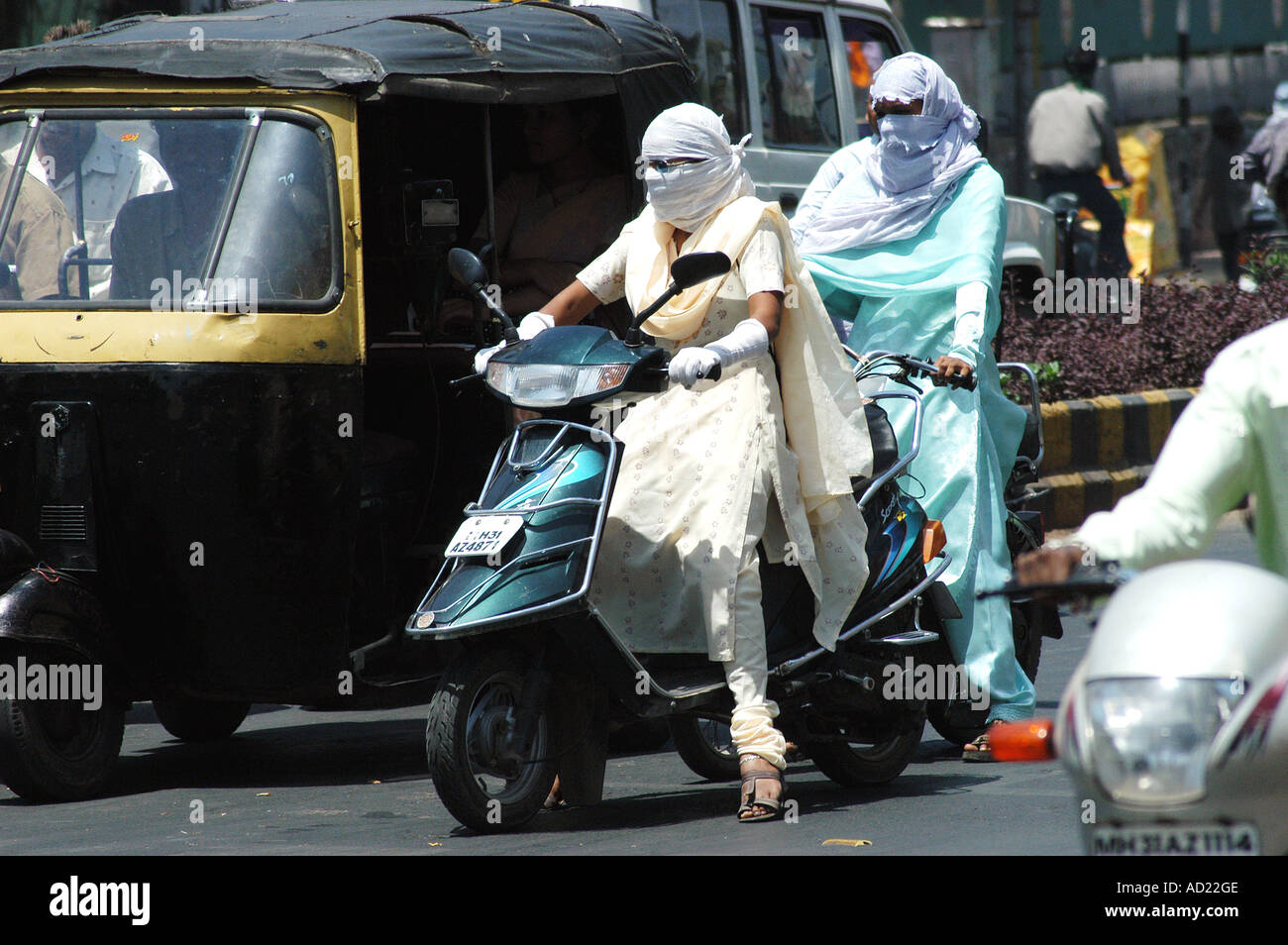 ASB73159 Two wheeler motor bike riders cover their faces with scarfs to avoid summer heat at Nagpur Maharashtra India Stock Photo