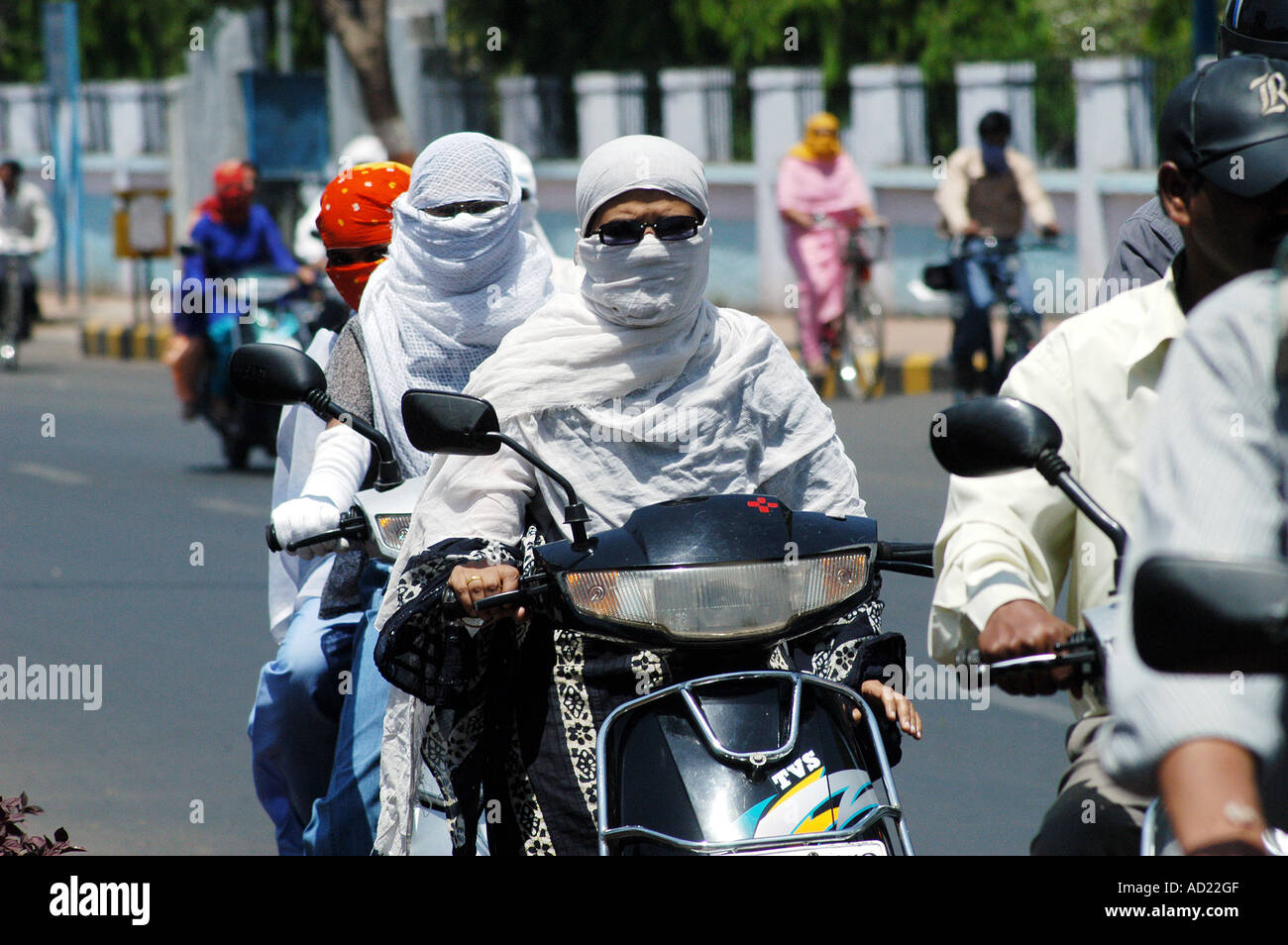 ASB73160 Two wheeler motor bike riders cover their faces with scarfs to avoid summer heat at Nagpur Maharashtra India Stock Photo