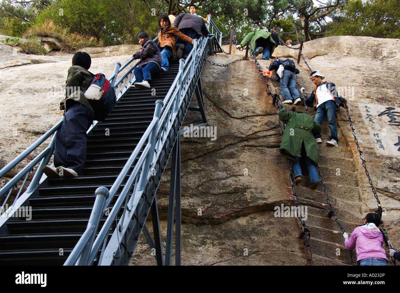 people climbing the steep steps on Hua shans granite peaked mountain 2160m Shaanxi Province China Stock Photo