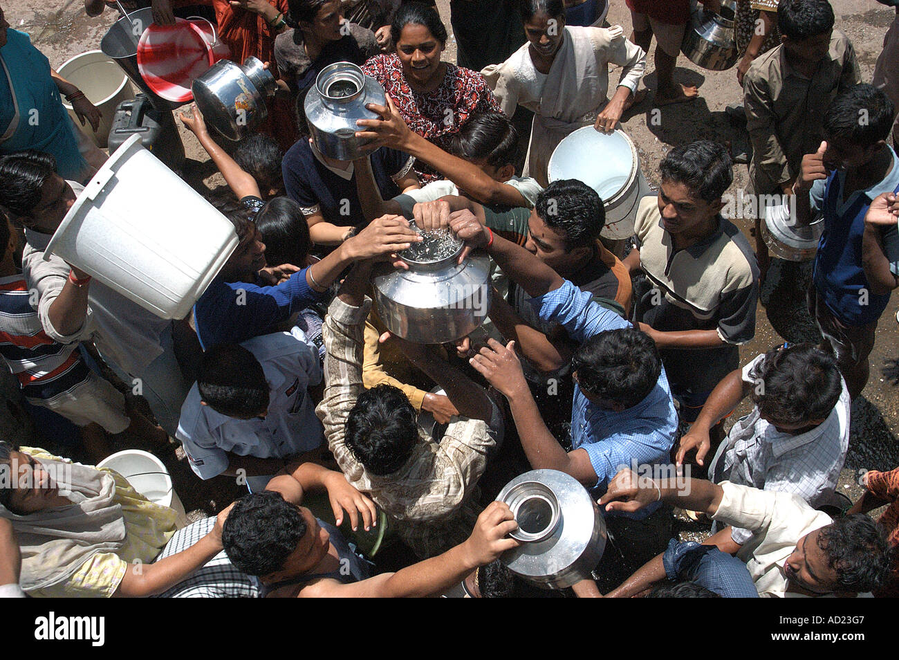 ASB72999 People fighting over water rushing towards pot full of water at Parel Bombay Mumbai Maharashtra India Stock Photo