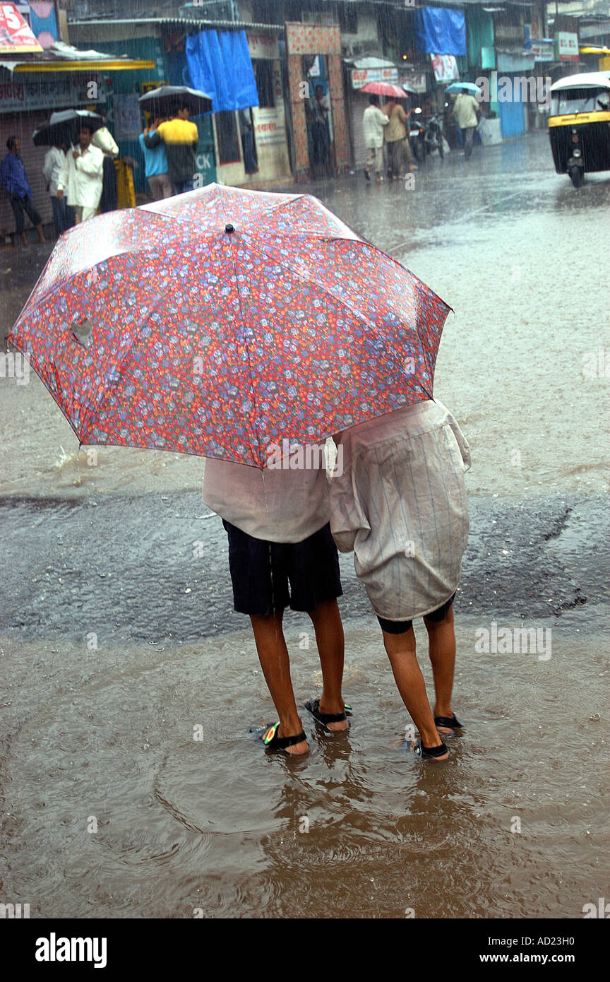 ASB73008 Two children sharing umbrella for protection from monsoon rains Stock Photo