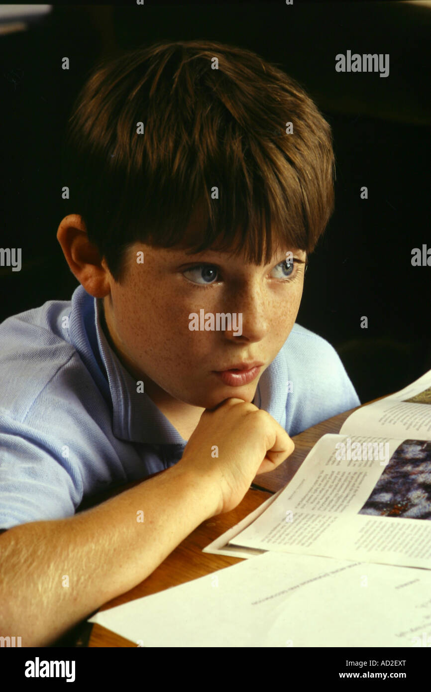 A young school boy is deep in thought as he studies at home Stock Photo ...
