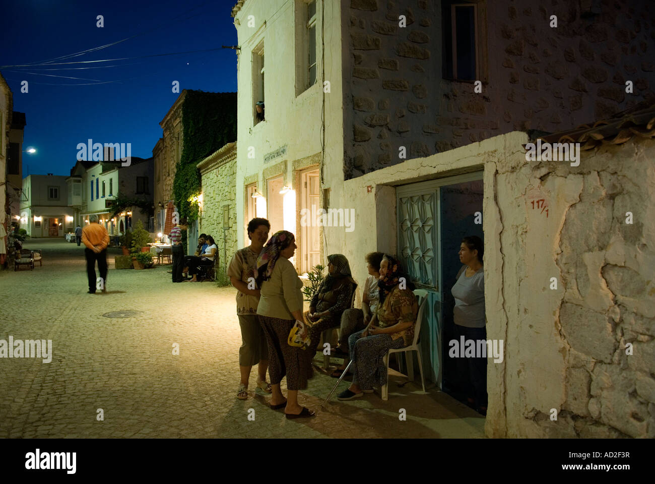 Local women chatting on a street Alacati Evenings, Turkey Stock Photo
