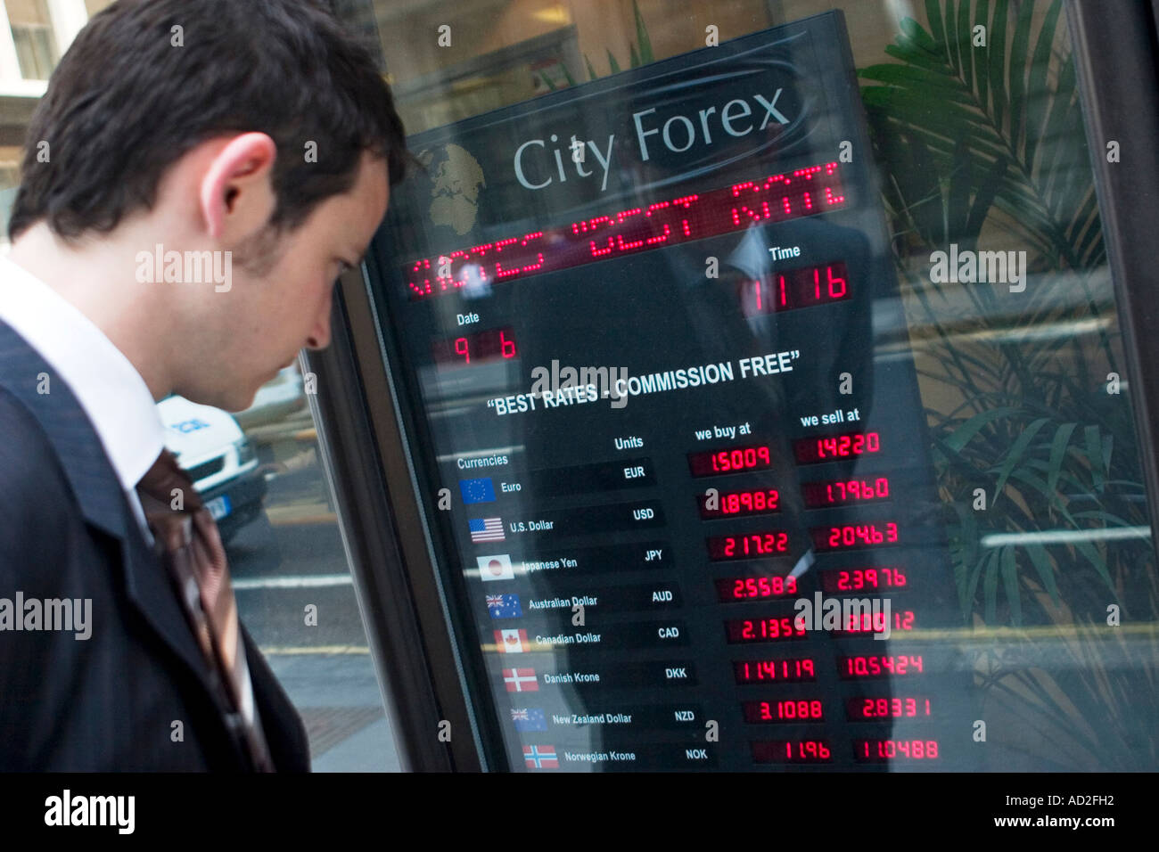 Young businessman looks at foreign exchange rates board in the City of London Stock Photo