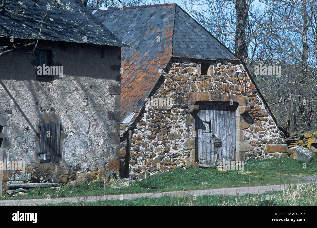 Auvergne stone famhouse with  wooden doors and black roof tiles Stock Photo