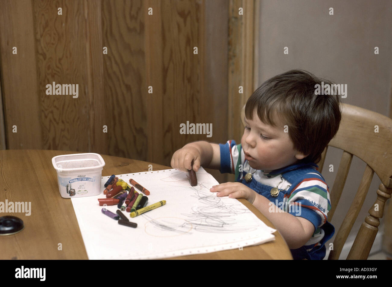 Little boy drawing a picture at the kitchen table Stock Photo - Alamy