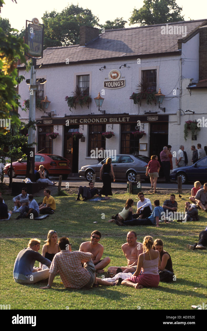 Wimbledon Common pub, group friends sitting on lawns outside the Crooked Billet pub having summer drink.  London pubs  SW19 UK 2000s 2001HOMER SYKES Stock Photo