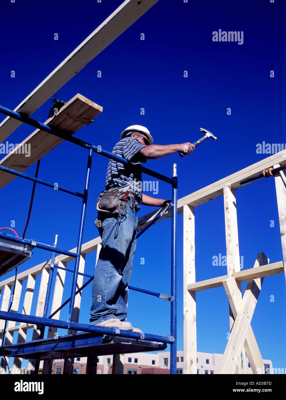 Construction worker using a hammer at construction site Stock Photo Alamy