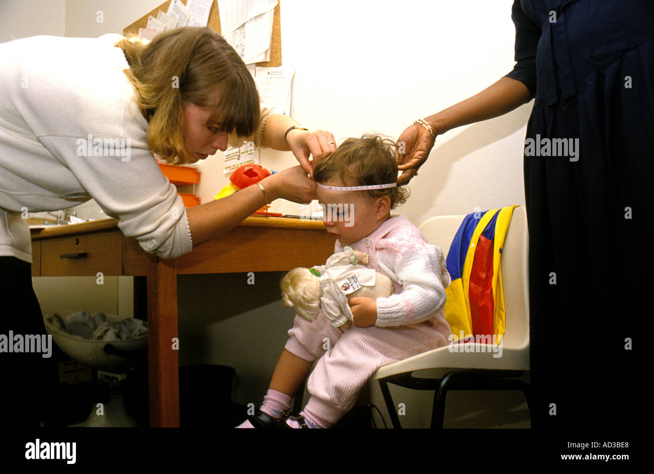 Health visitor checking toddler head circumference Stock Photo Alamy