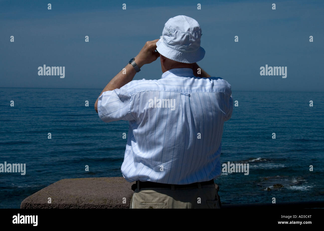 Man looking out to sea with Binoculars Alghero Sardinia Stock Photo - Alamy