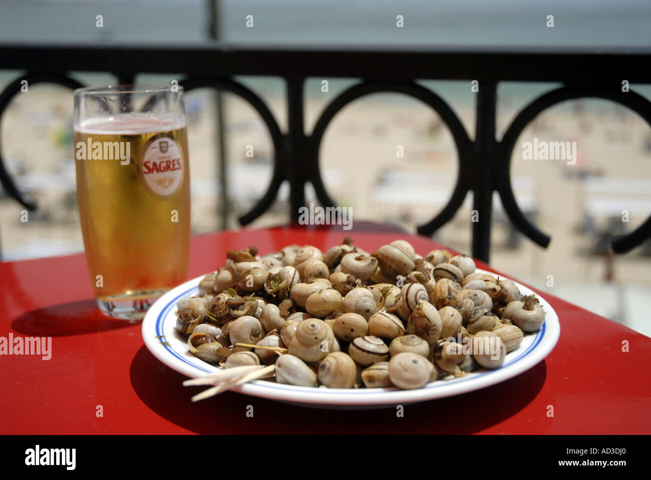 A lunch of beer and snails on a beachside terrace offers ample fuel for an afternoon exploring the old town of Cascais (Portugal Stock Photo