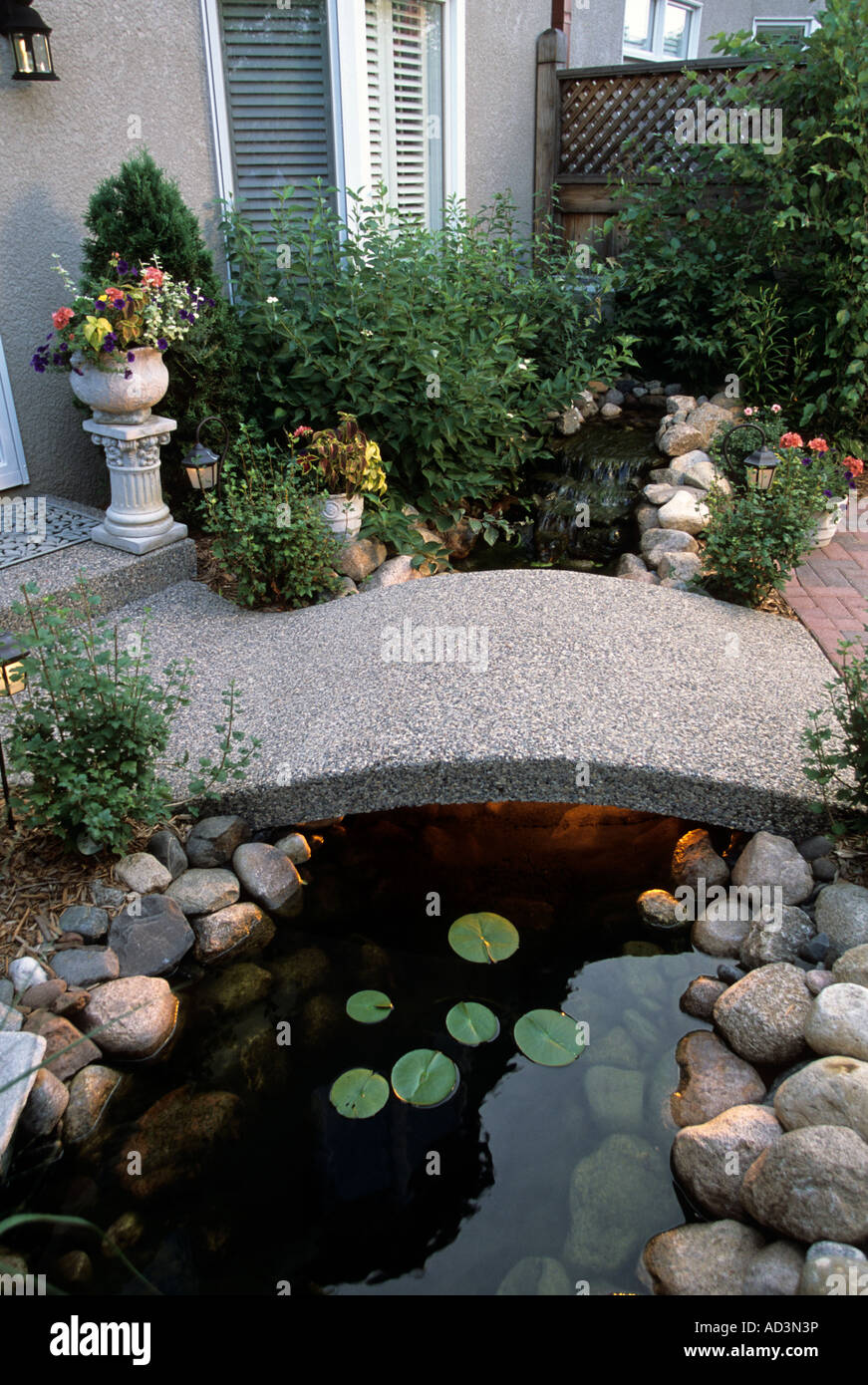 MINNEAPOLIS, MINNESOTA TOWNHOUSE PATIO GARDEN HAS SMALL STREAM, BRIDGE