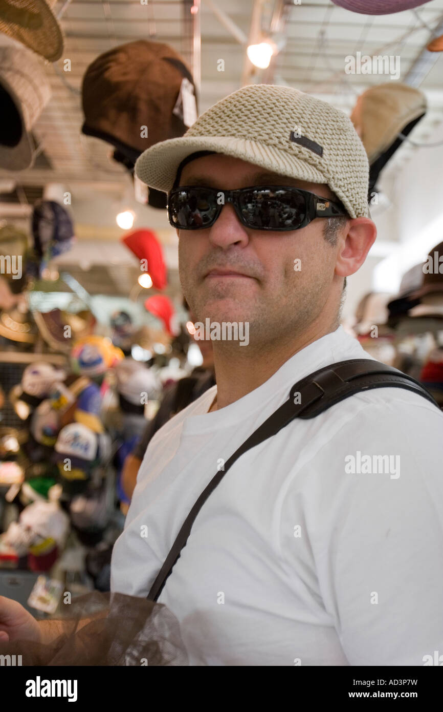 Portrait of a man trying on a white billed cap in a hat shop Stock Photo