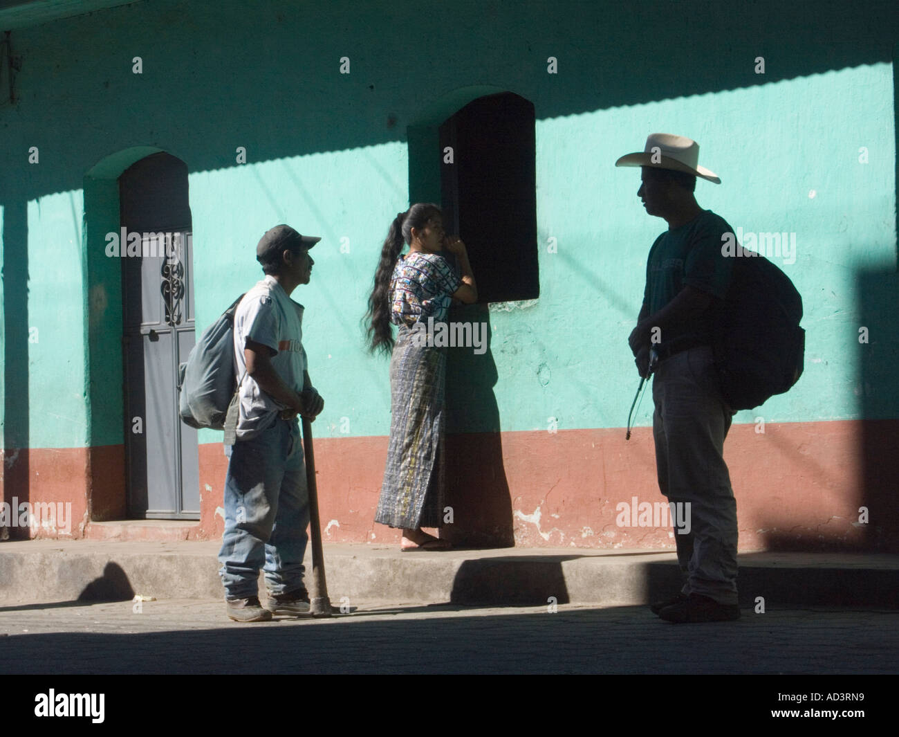 In the highlands of Guatemala, local people walk past colonial Spanish buildings painted with bright colors Stock Photo