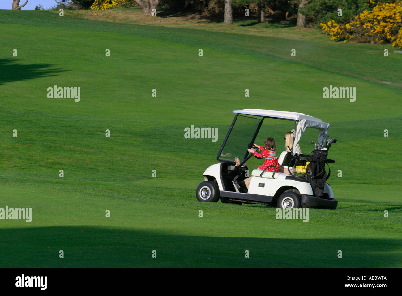 Young girl driving golf cart on Victoria Golf Course in evening