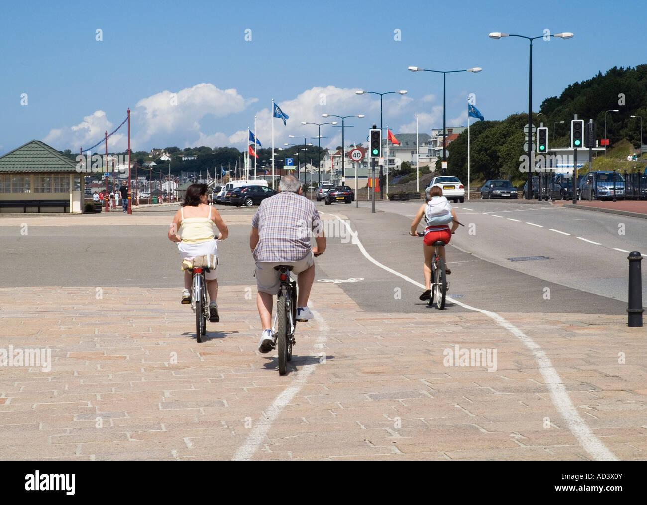 dh St Aubin Bay ST HELIER JERSEY Tourist family riding bikes along Esplanade promenade cycling bike Stock Photo