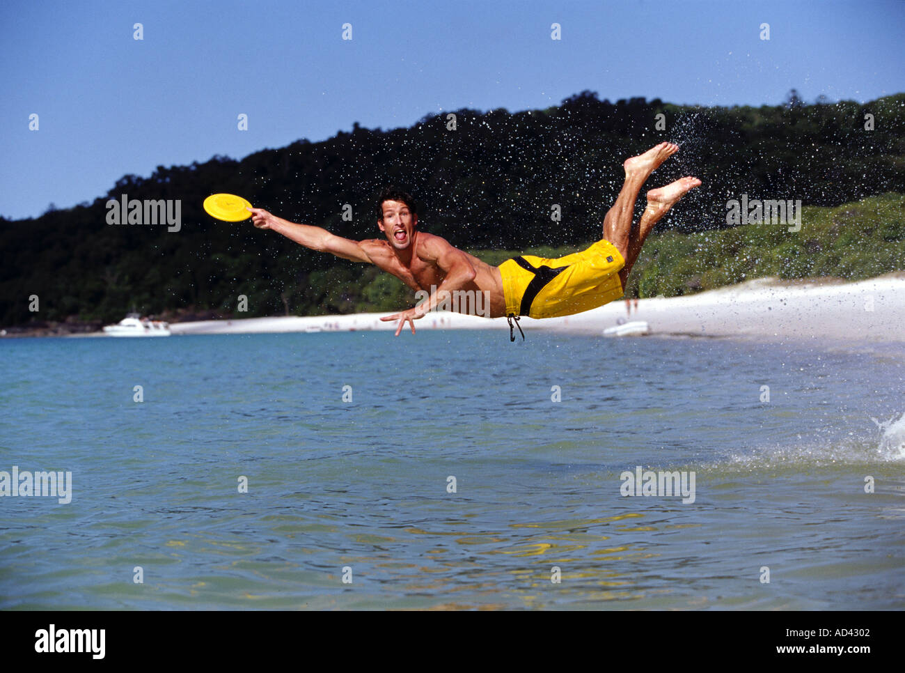 Man leaping in air to catch frisbee Location Australia Queensland