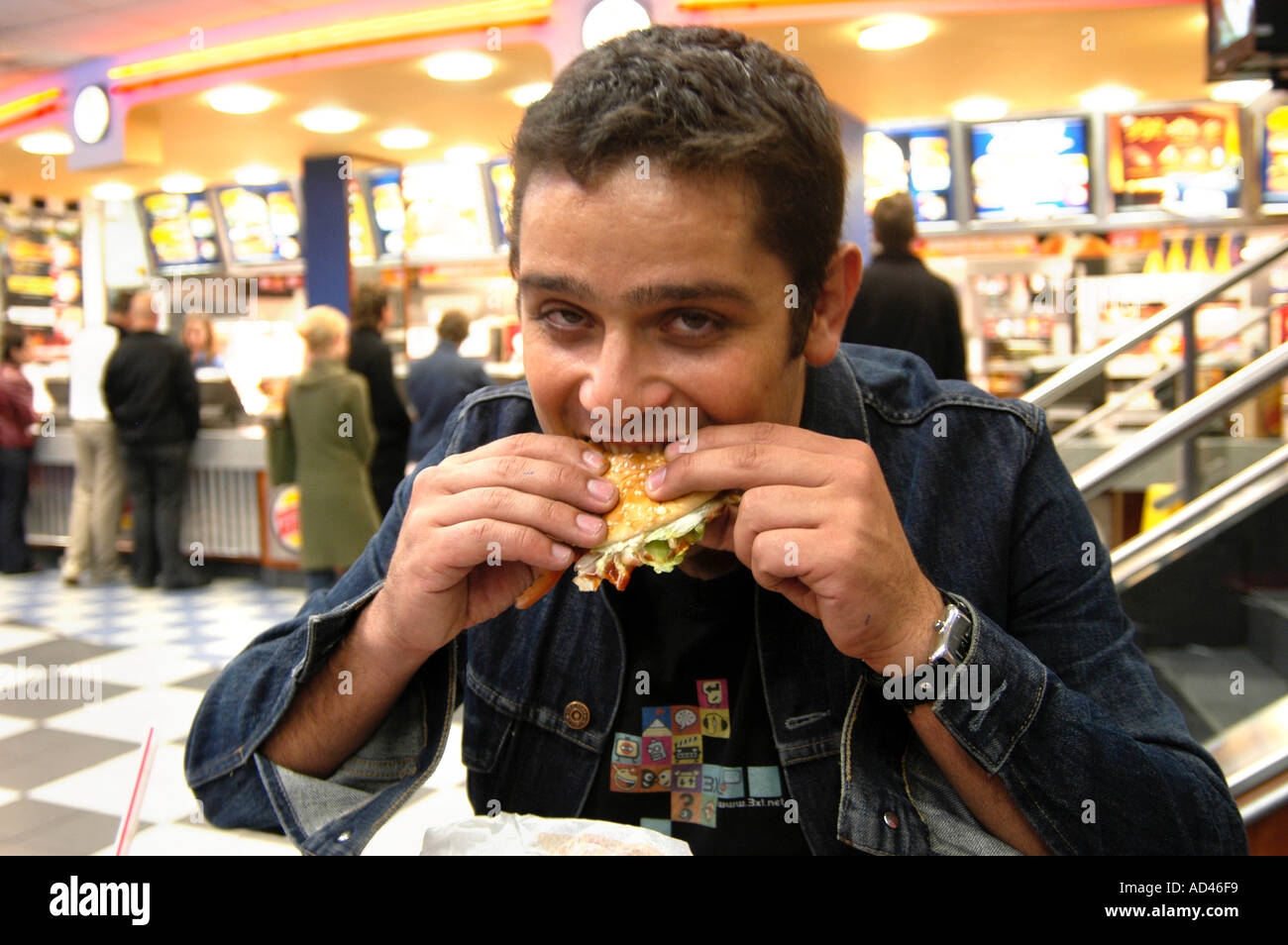 Man eating hamburger at Burger King London England UK Stock Photo