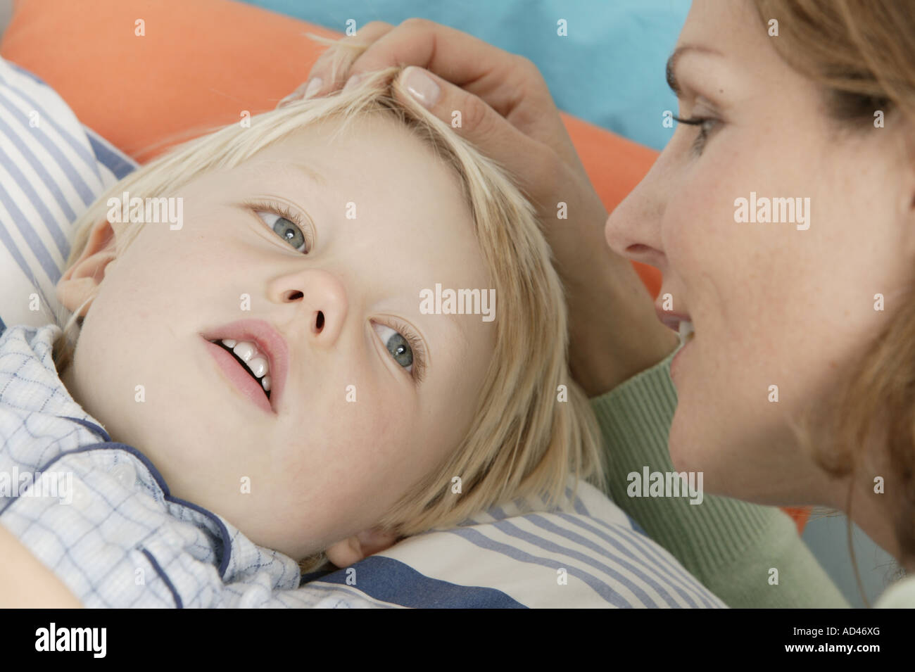 Mother brings her son to bed Stock Photo