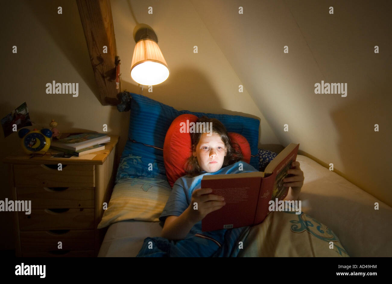 Girl reads in her bed Stock Photo