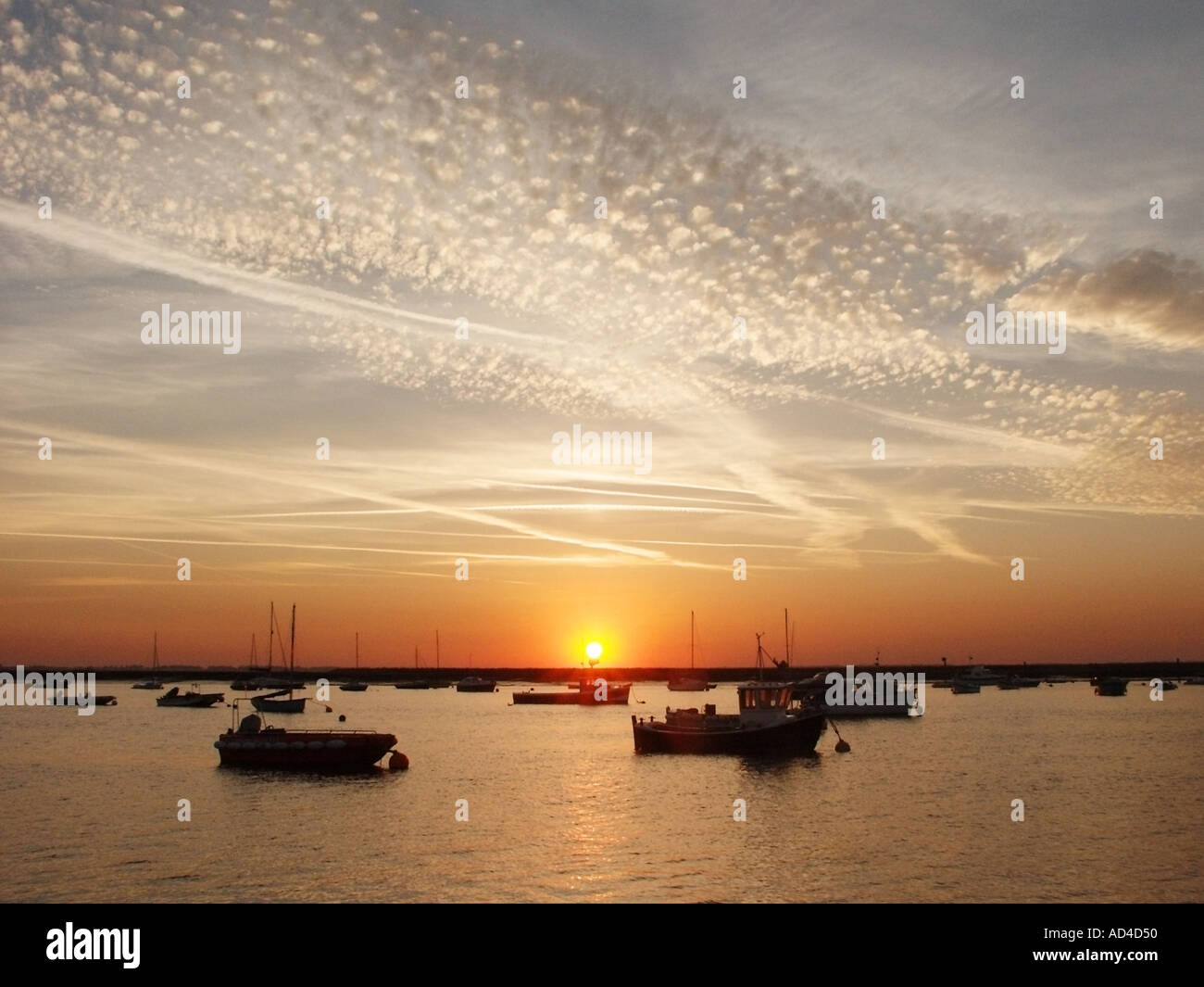 West Mersea Essex sunset and boats at moorings at low tide on the
