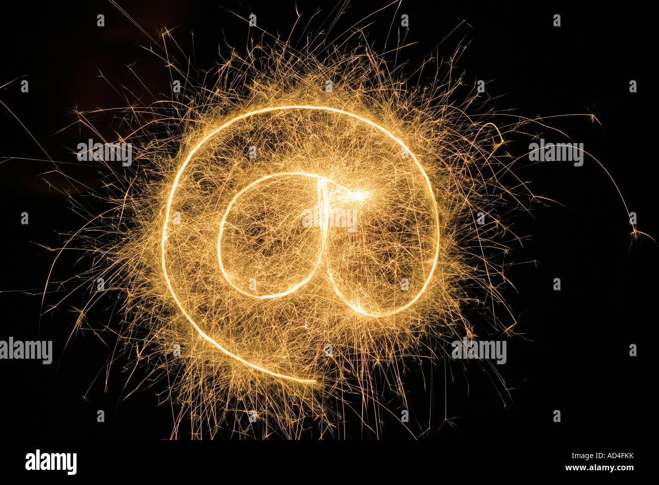 At' Symbol drawn with a sparkler Stock Photo