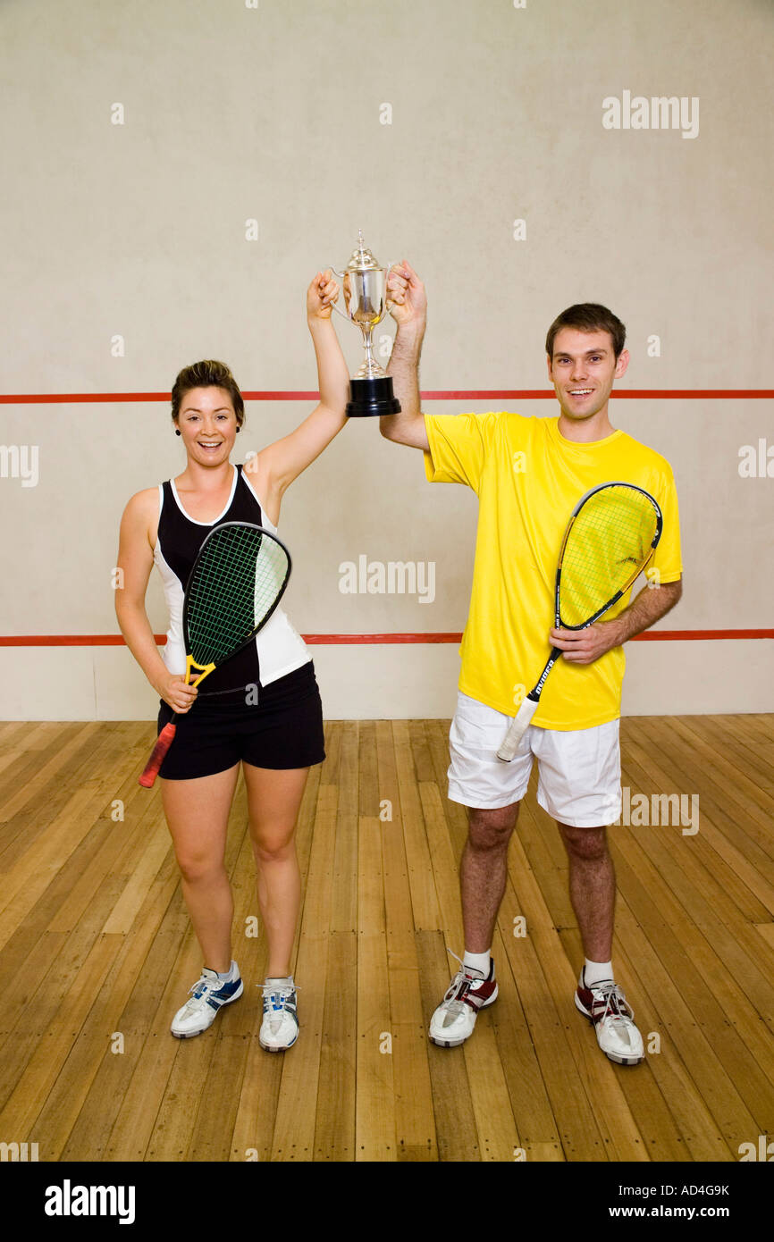 Two squash team mates holding a trophy Stock Photo