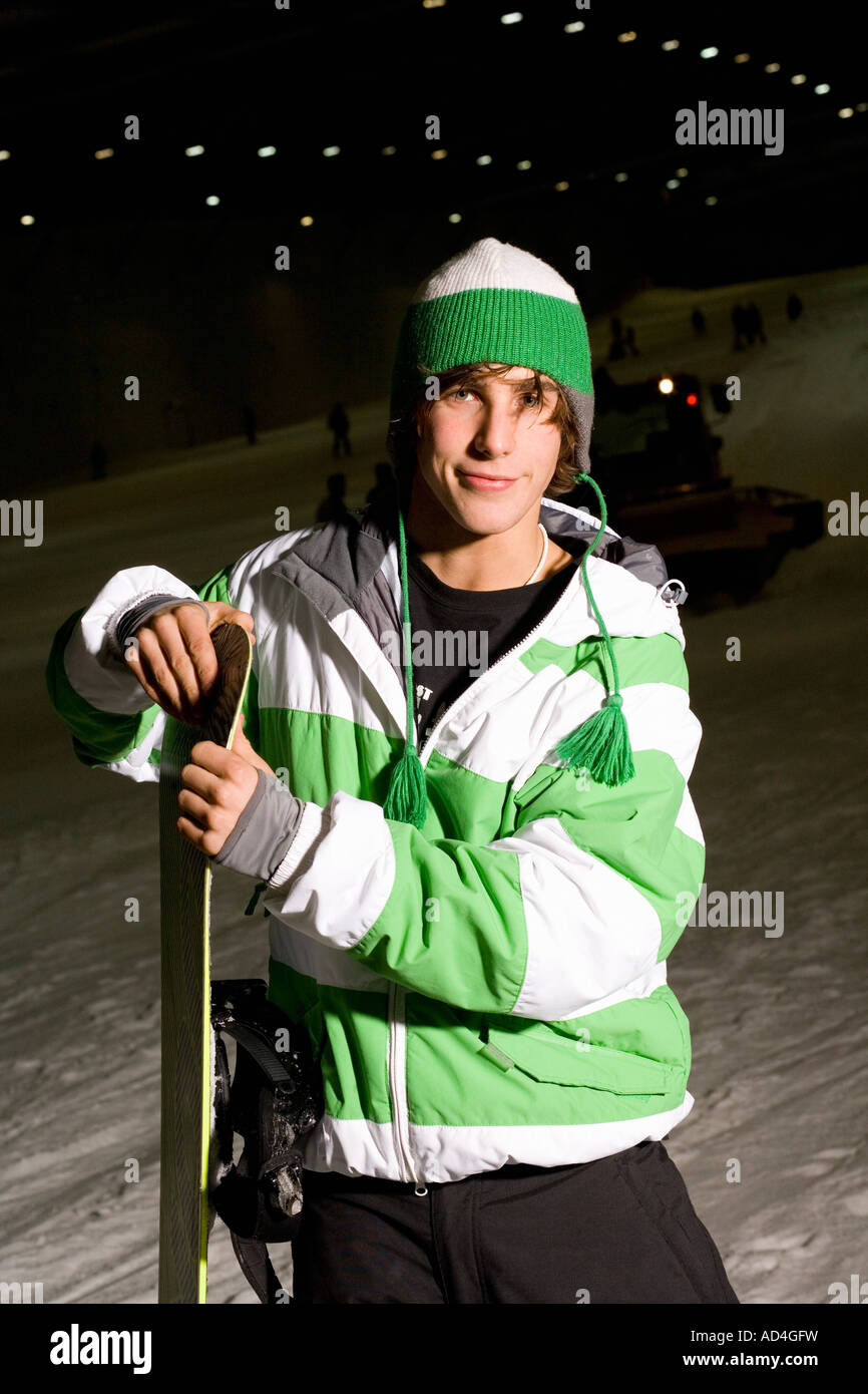 Young man standing on a ski slope with a snowboard Stock Photo