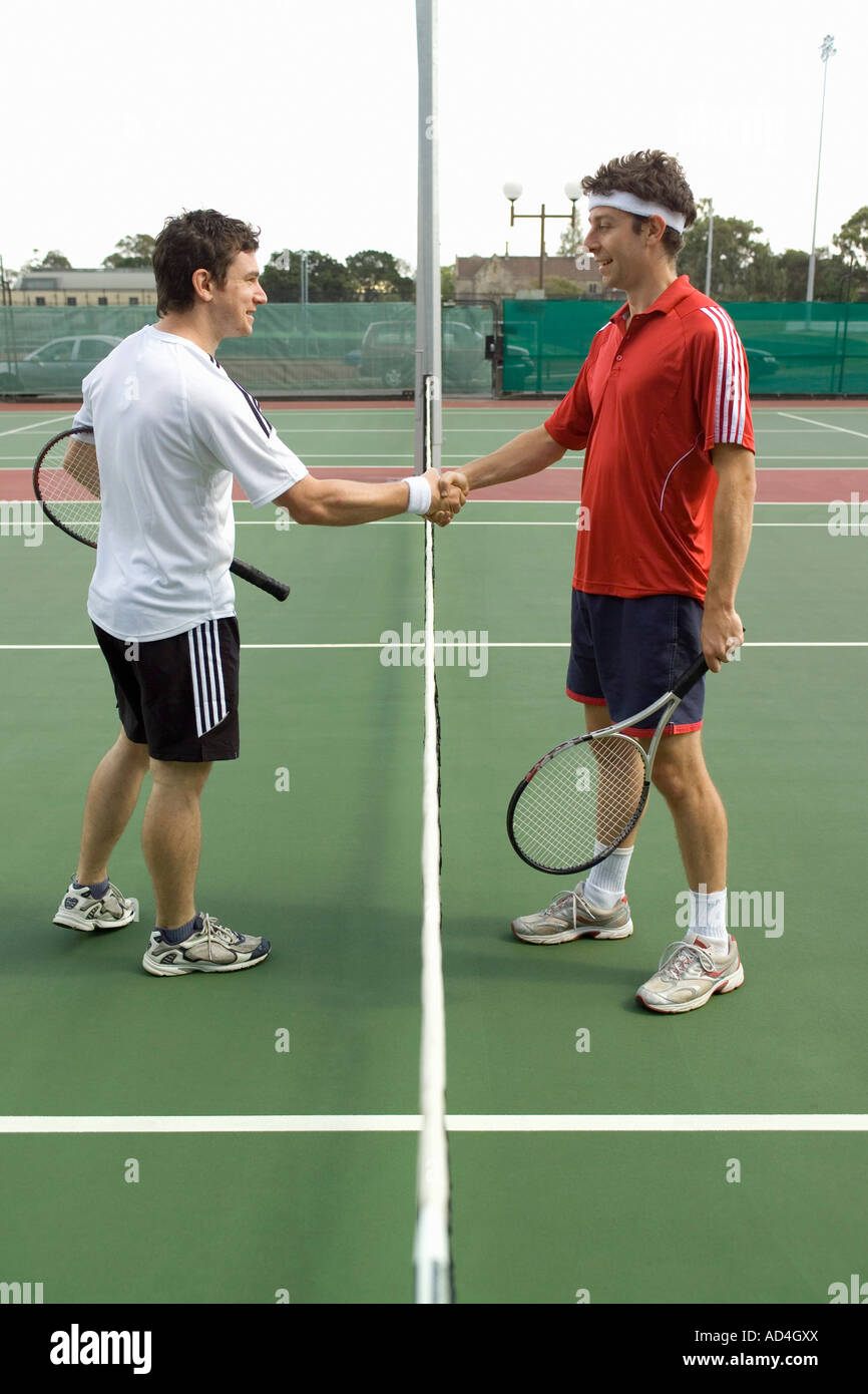 Two tennis players shaking hands across the net Stock Photo