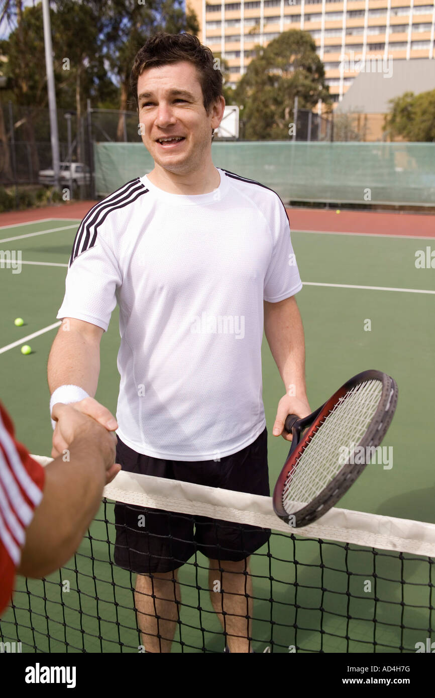 Two tennis players shaking hands across the net Stock Photo
