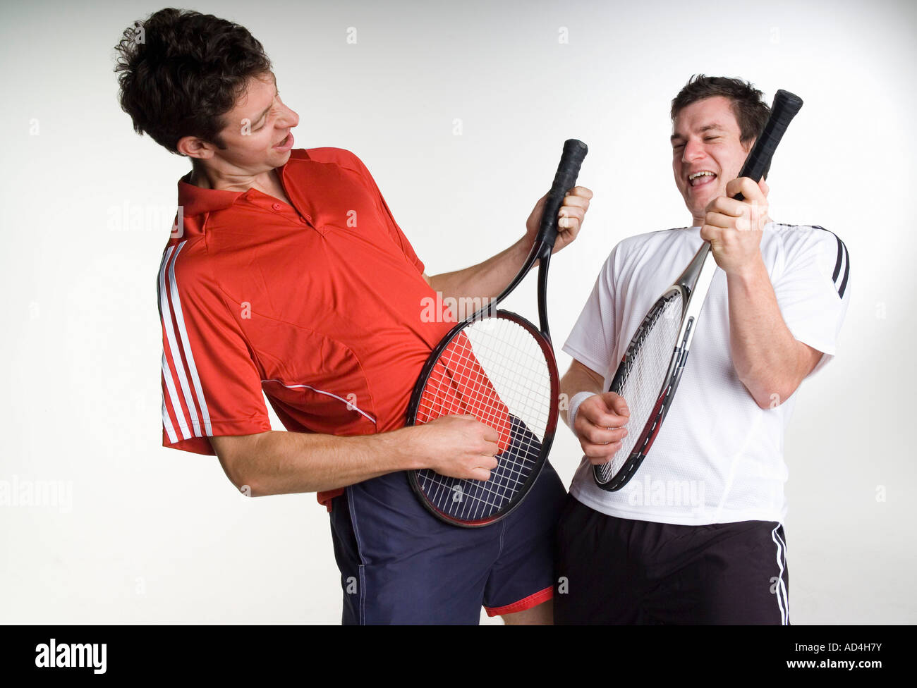Two tennis players playing air guitar with their racquets Stock Photo