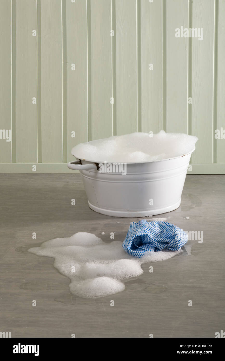 A bucket of soapy water and a cloth on the floor Stock Photo