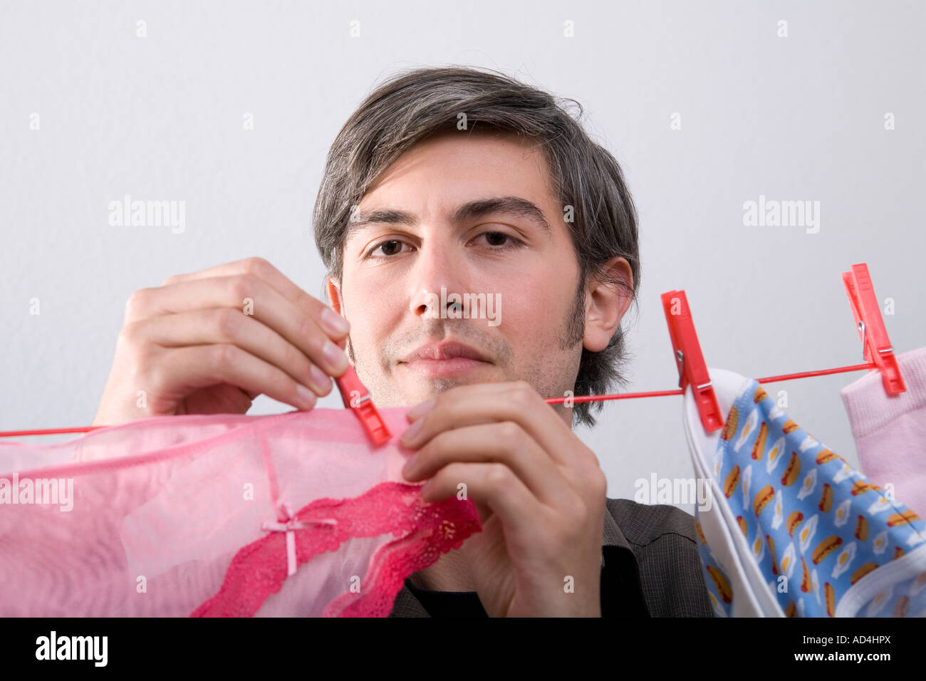 A man hanging underwear on a clothesline Stock Photo