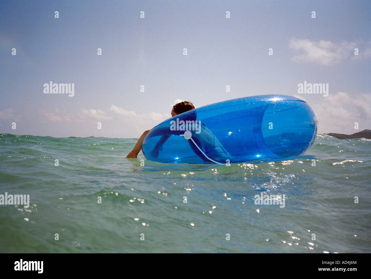 A woman floating on an inner tube in the sea Stock Photo Alamy