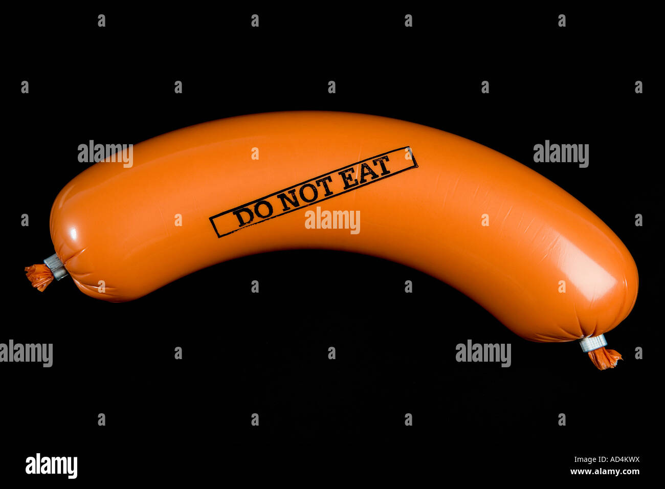 A sausage wrapped in plastic packaging and stamped 'Do Not Eat' Stock