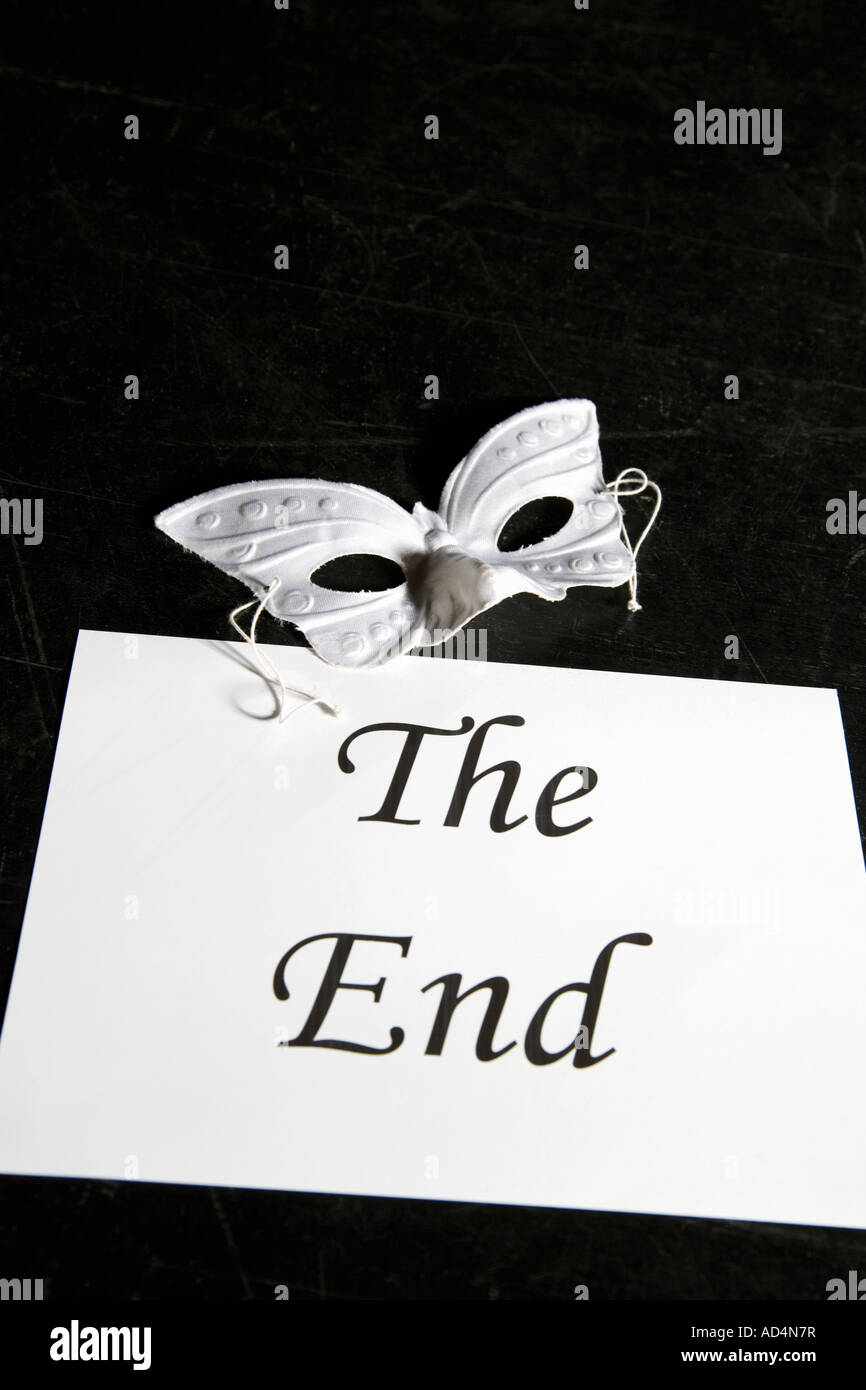 A mask and a sign for 'The End' on a theater stage Stock Photo
