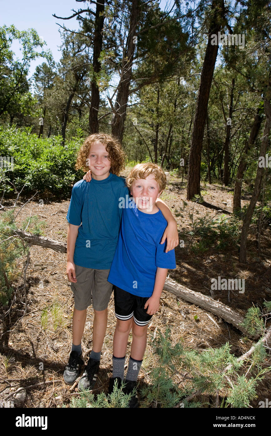 Two boys standing together in a forest Stock Photo