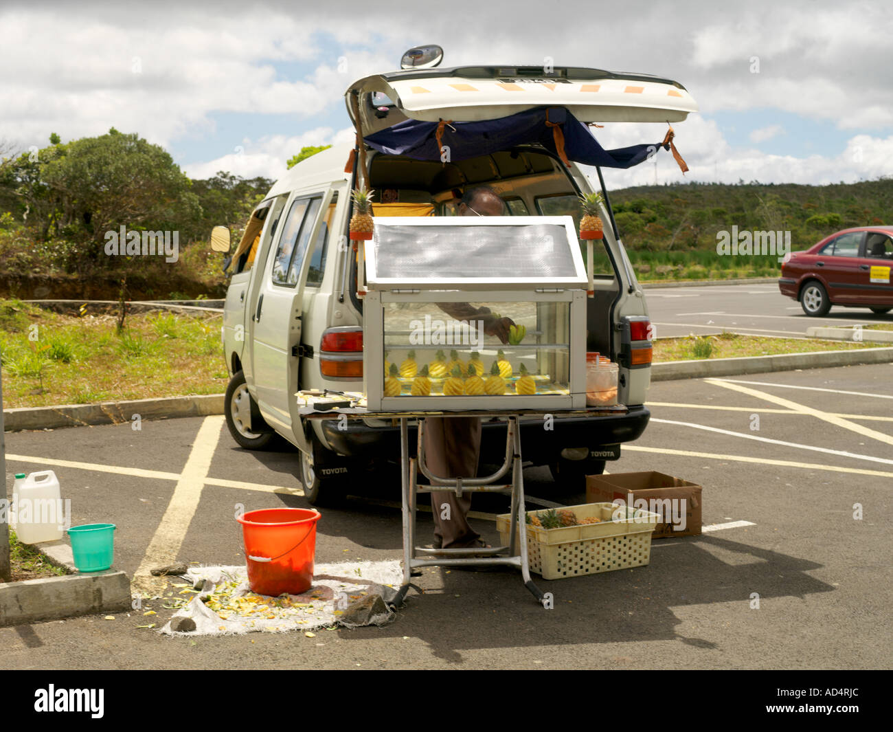 Charmarel Mauritius Man Selling Pineapples Ready Peeled from Car Boot in Car Park Stock Photo