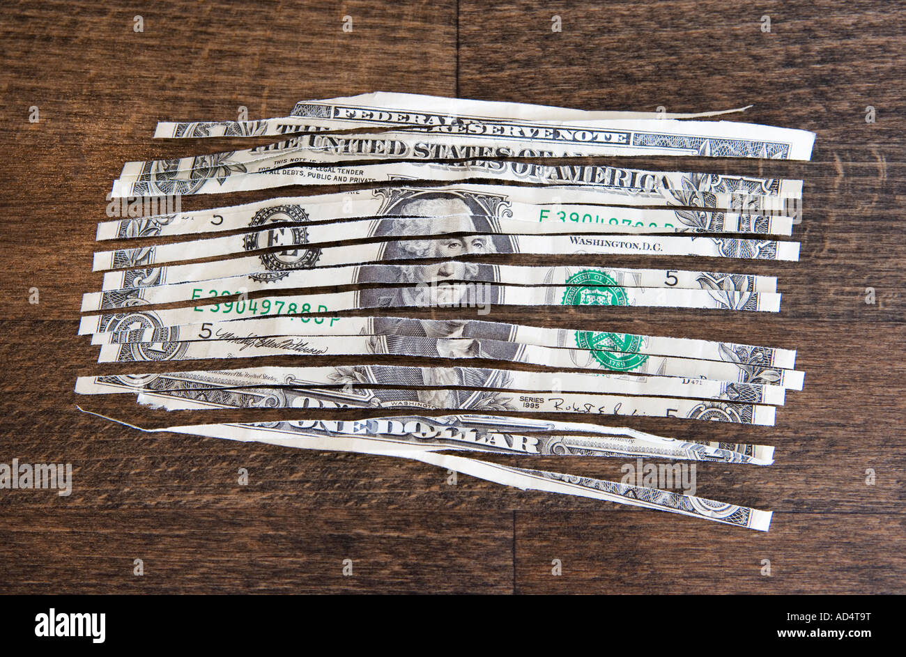 A shredded one dollar note on a wooden table Stock Photo