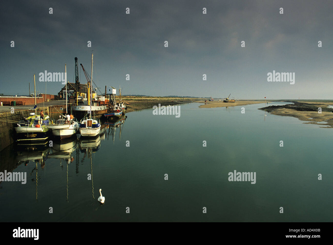 Early morning light on the fishing boats tied up at Wells Next the Sea Norfolk Stock Photo