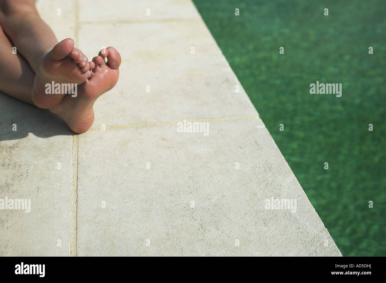 View of feet by the swimming pool Stock Photo - Alamy